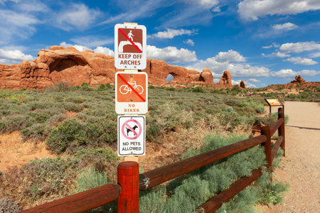 Visitor Restriction Sign near The Windows Viewpoint and Trail in Arches National Park, Utah, United States. Keep off arches, No bikes, and No pets signs.の写真素材