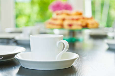 Raspberry Streusel Cake sliced on a table with dishes and coffee cupsの写真素材