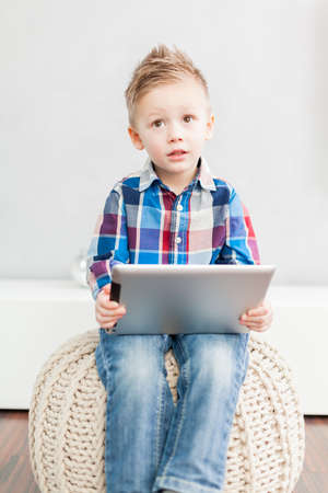 Boy sitting  in the living room using a tablet pc