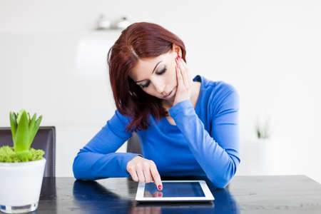 Attractive woman with Tablet PC sitting at tableの写真素材