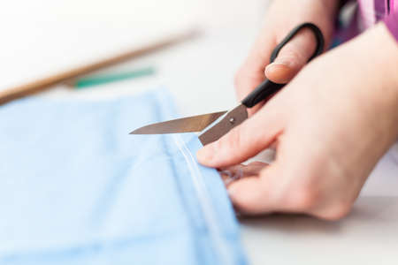 Scissors cutting blue tissue