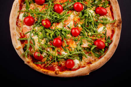 Traditional italian pizza with cherry tomatoes on a dark background.の写真素材