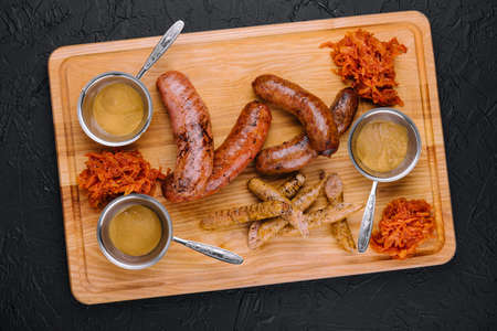 Delicious fresh grilled sausages on wooden tableの写真素材
