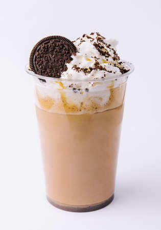 Chocolate milkshake covered with whipped cream in plastic glass isolated