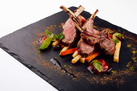 roasted lamb rack served with carrot, yellow curry and lamb sauceの写真素材