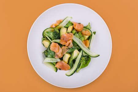 Salmon avocado salad with salted fish, lettuce, broccoli and cucumbersの写真素材