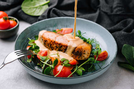 Grilled salmon with vegetables and sour cream sauceの写真素材