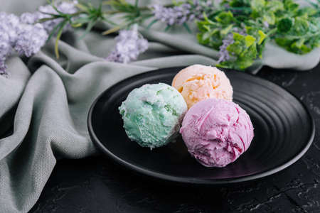Three scoops of ice cream on dark plateの写真素材