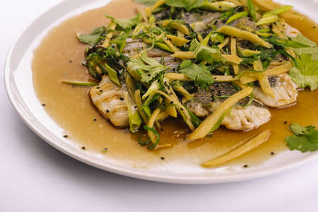 Fried fish fillet. cod with sauce and herbsの写真素材