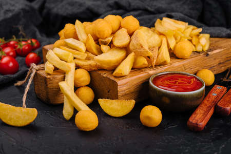 Assorted beer snacks like potato wedges, french fries and cheese ballsの写真素材