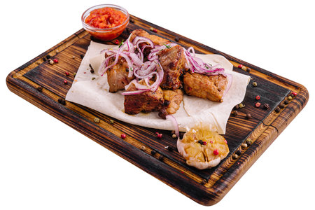 Serving of barbecue with sauce and pickled onions on a wooden boardの写真素材