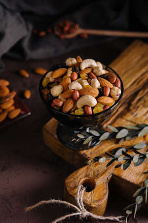 Bowl with mixed organic nuts on wooden boardの写真素材