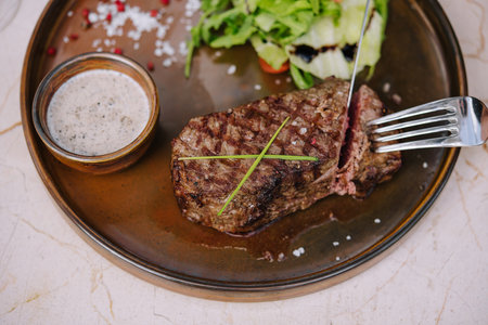 Piece of steak cut with a fork and knifeの写真素材