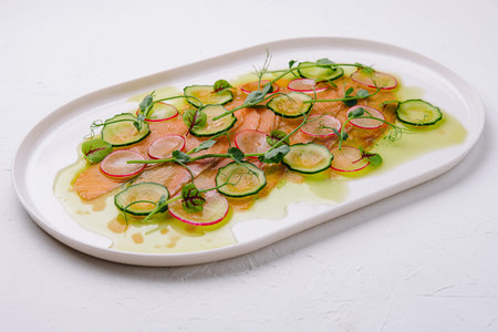 Buffet serving of pickled salmon slices with radish, cucumberの写真素材