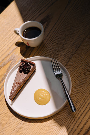 Chocolate cake with a coffee cup on wooden tableの写真素材