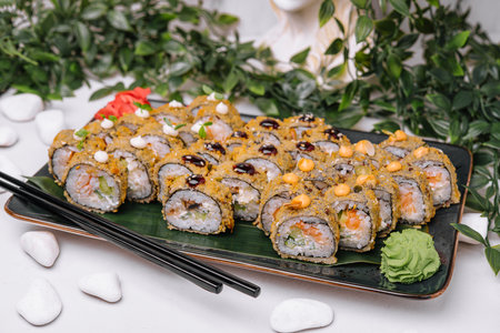 Served warm sushi with ginger and wasabi on a black stone plate.の写真素材
