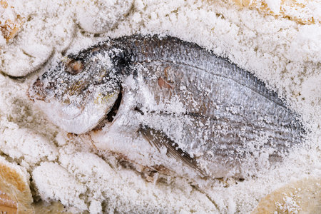 Preparing salt-baked dorada fish top viewの写真素材