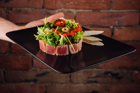tuna tartare served with toast and salad on black stone plateの写真素材