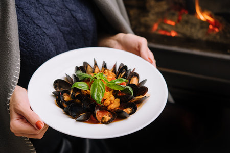 Delicious fresh steamed mussels in white wine sauce in a white plateの写真素材