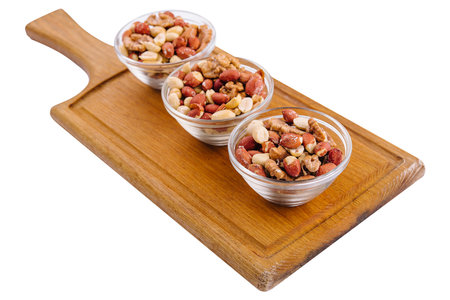 Assorted nuts in a glass bowls on woodenの写真素材