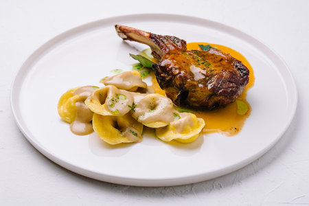 tomahawk steak and ravioli on plateの写真素材