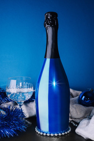 Holiday Bottle of champagne and Christmas toys over blue backgroundの写真素材