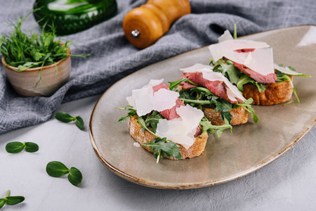 Bruschetta with beef, arugula and parmesan cheeseの写真素材