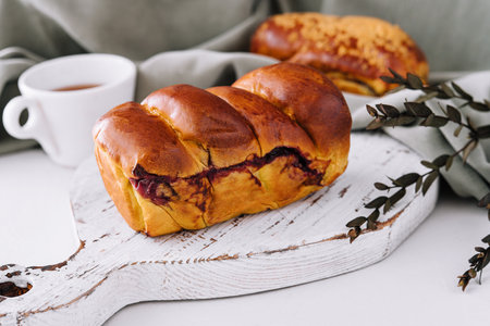 Delicious baked bun with cherry on white woodの写真素材