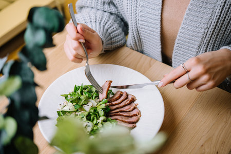 Woman eats Vitello Tonnato in restaurantの写真素材