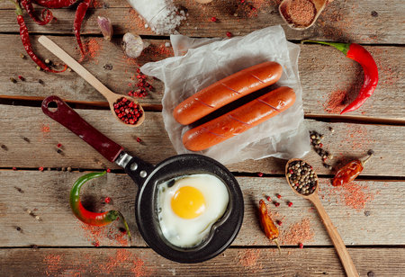 Delicious breakfast with heart shaped egg and sausagesの写真素材