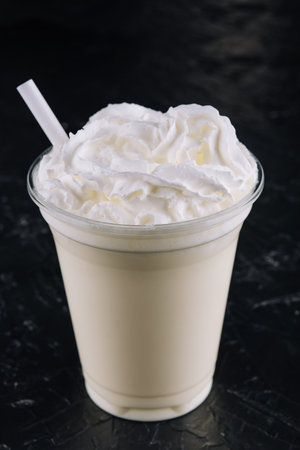 Glass with white milkshake and creamの写真素材