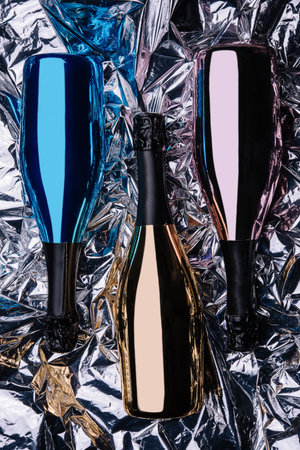 three different bottles of champagne on foil backgroundの写真素材