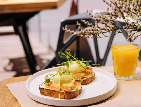 Bread Toast with smashed Avocado, Salmon and Poached Egg and orange juice