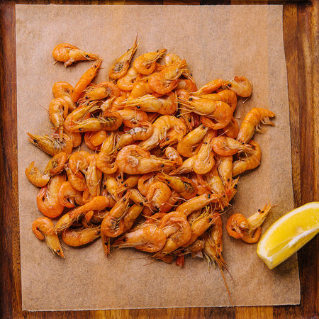 Small cooked shrimp on wooden tray
