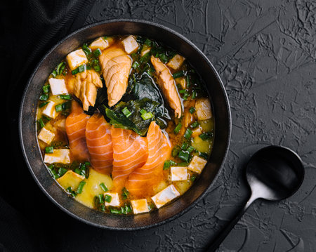 Appetizing ishikari miso soup with salmon in a black bowlの写真素材