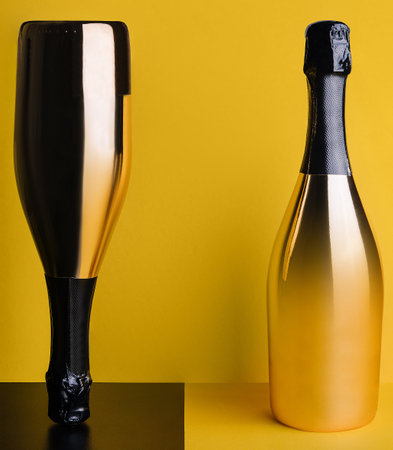two elegant bottles of champagne on a yellow-black backgroundの写真素材