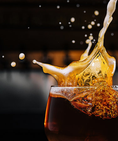 closeup splashes glass of dark Belgian beer