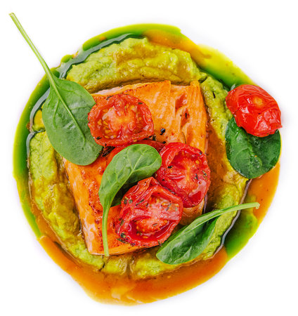 salmon steak with mashed avocado, decorated with basil leaves and cherry tomatoesの写真素材