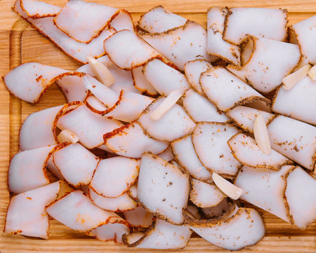 Tasty salted smoked lard on wooden surfaceの写真素材