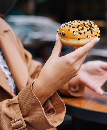 woman eating donuts on the street terrace of the barの写真素材