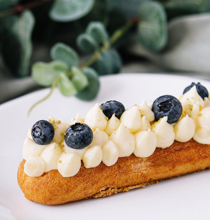 Tasty French eclairs with cream and fresh berriesの写真素材