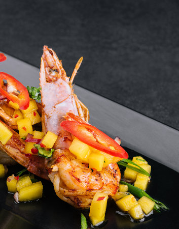 Skewers barbeque grilled prawns on black plateの写真素材