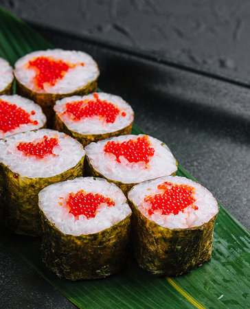 Maki Sushi with red caviar on black plateの写真素材