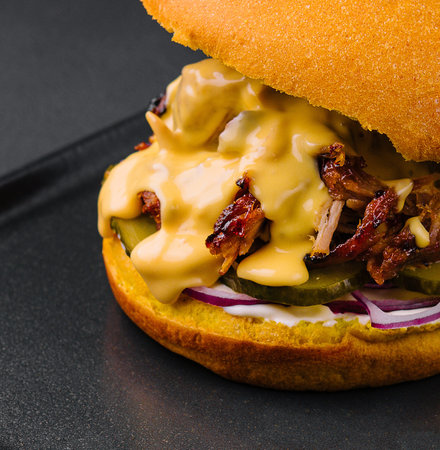 delicious burger with torn meat on black trayの写真素材