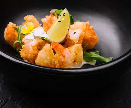 fried crispy shrimp on black plateの写真素材