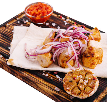 Chicken fillet skewers on tortilla served with red onionの写真素材
