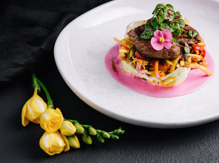 Beef medallions with fresh salad on plateの写真素材