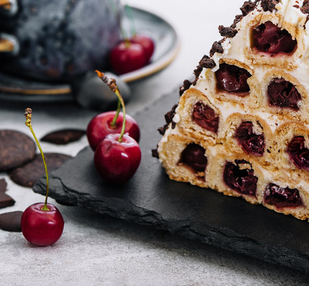 Triangle cherry cake with cream and chocolate sprinklesの写真素材