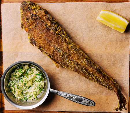 fried fish on wooden board with spicy sauce