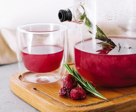 fruit raspberry tea in glass teapot and cupの写真素材